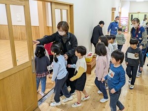 模擬Jアラートを受け園児を避難誘導する写真