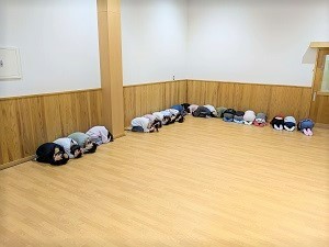 窓から離れ園児が避難姿勢を取る写真