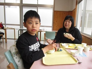 児童1名とと職員1名が会食をする写真