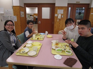 児童2名と職員2名が食事を食べる写真