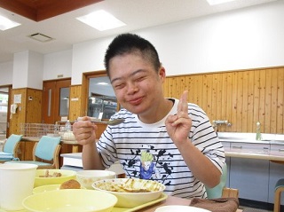 食事を食べながらピースサインをする児童の写真