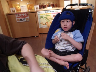 座って梨の試食をする児童