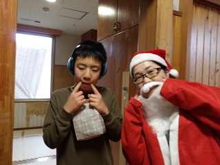 サンタと並んでポーズを取る児童