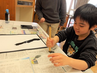 勢いよく筆を動かす児童