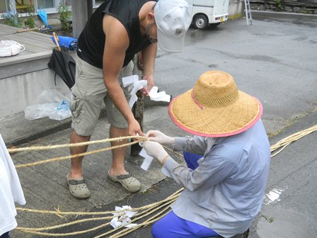 八注連竹を固定する縄に注連を取り付ける様子の写真