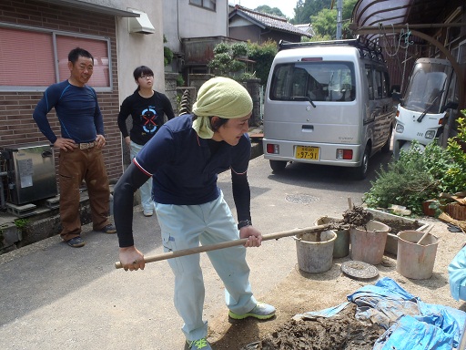 土壁の材料を渡す様子